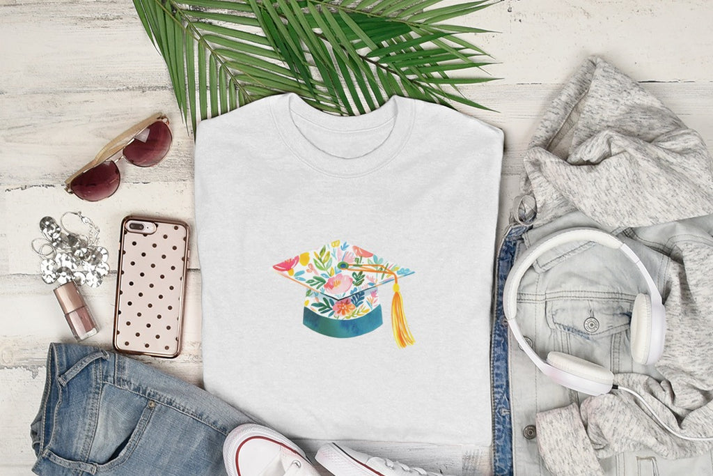 White t-shirt with graduation cap illustration featuring colorful floral design.