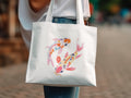 White tote bag with a colorful koi fish illustration.