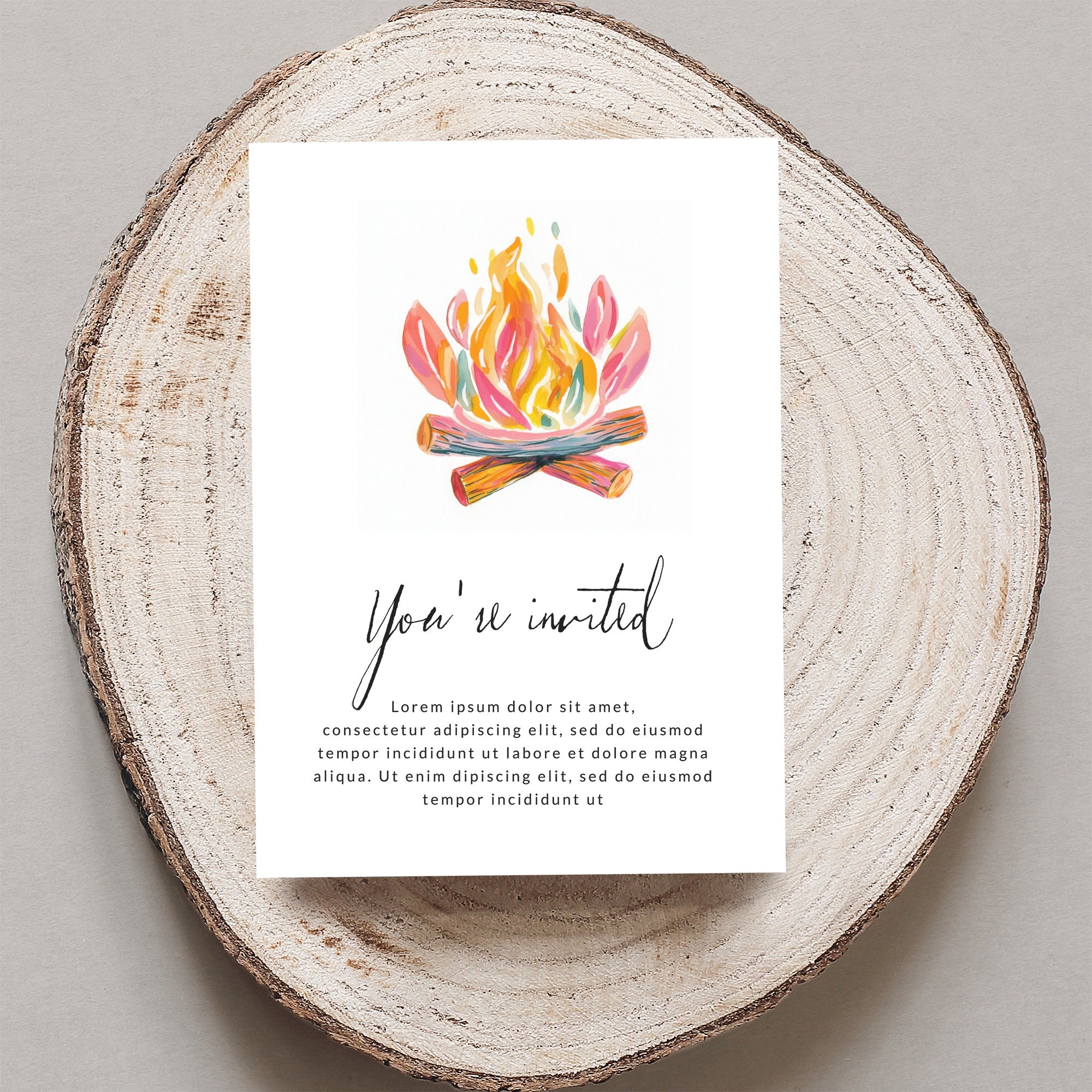 Invitation card with "You're invited" and placeholder text on wood slice.