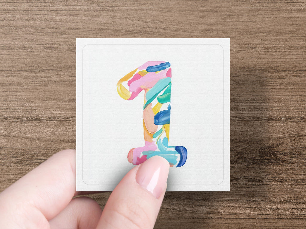 Hand holding card with colorful painted number 1.