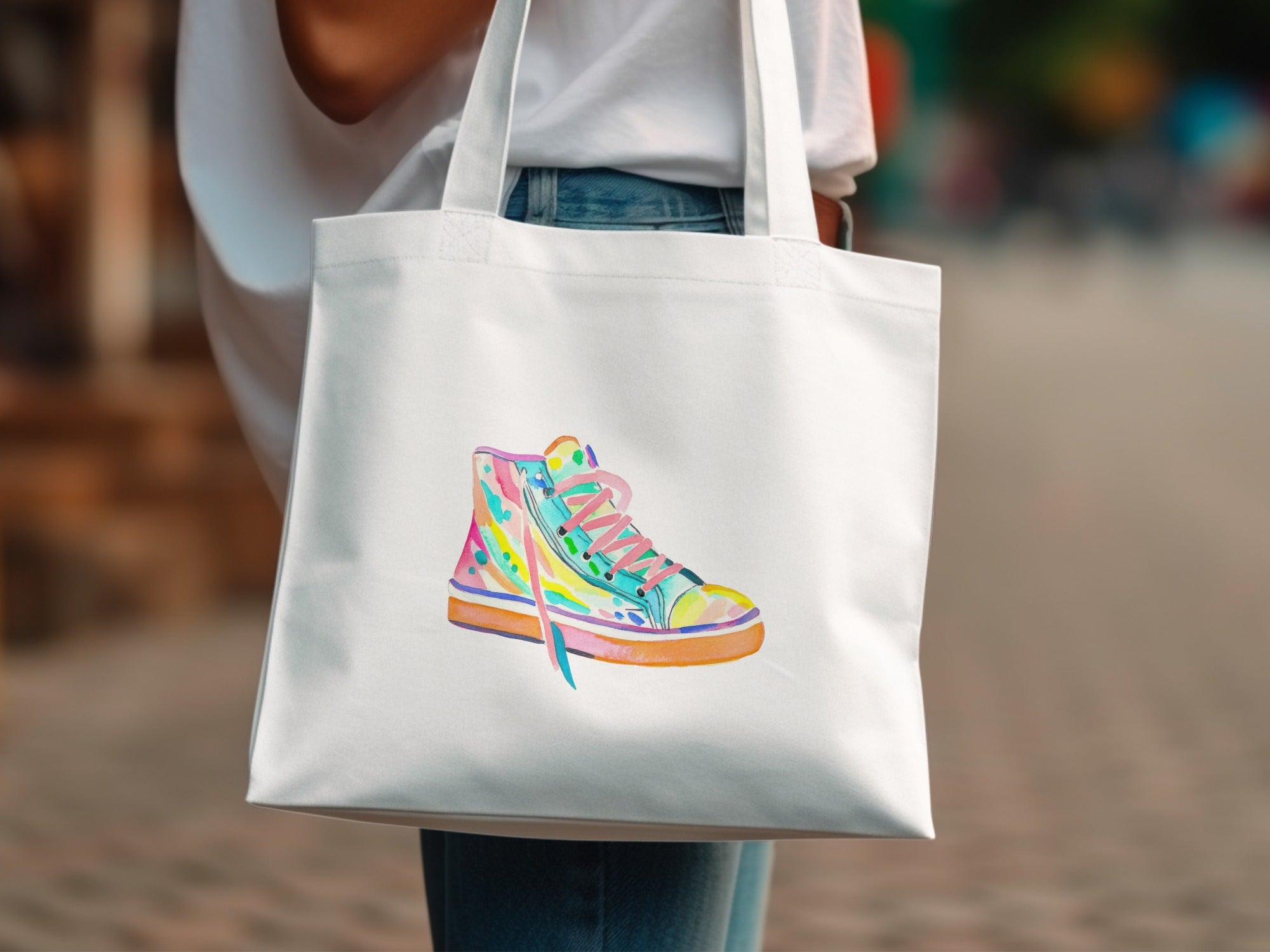 White tote bag with watercolor illustration of a colorful high-top sneaker.