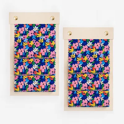 Two fabric swatches with a colorful floral pattern on a dark blue background.