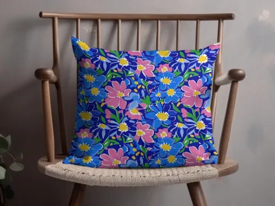 Blue pillow with a repeating pattern of pink and yellow flowers.