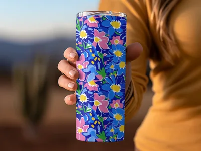 Blue tumbler with a vibrant floral pattern of pink and yellow flowers.