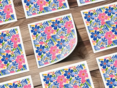 Floral pattern with pink and blue flowers and green leaves on a wooden background.