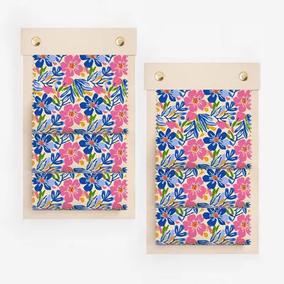 Two fabric swatches with a colorful floral pattern of blue, pink, and yellow flowers on a white background.