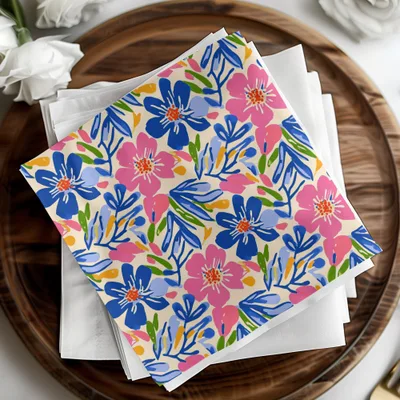 Colorful floral patterned napkins stacked on white napkins on a wooden tray.