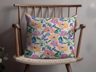 Floral patterned throw pillow on a wooden chair.