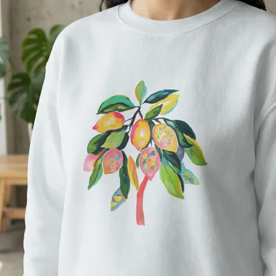 White sweatshirt with a colorful painted lemon branch design.