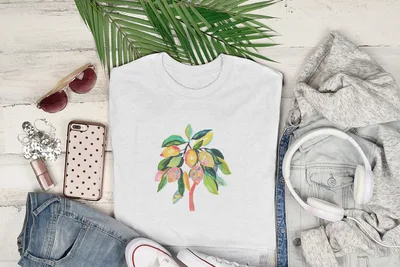 White t-shirt with colorful lemon branch design, styled with jeans and headphones.