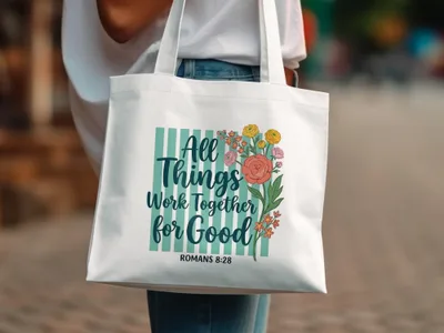 White tote bag with "All Things Work Together For Good" and floral design.