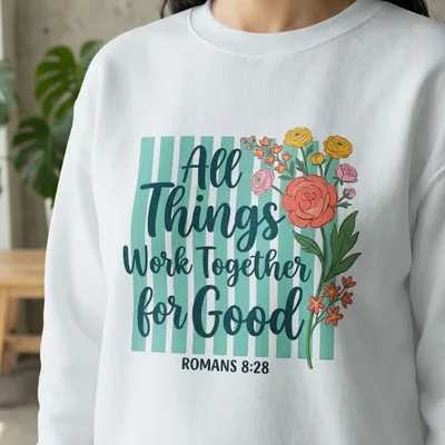 White sweatshirt with "All Things Work Together for Good" and floral design.