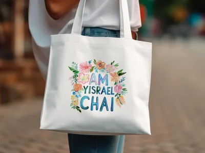 White tote bag with "Am Yisrael Chai" text surrounded by flowers.