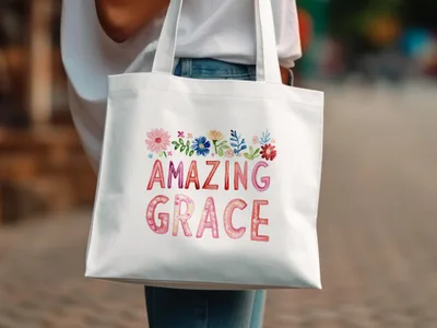 White tote bag with "AMAZING GRACE" text and floral decorations.