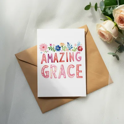 "Amazing Grace" card with floral accents, resting on a brown envelope.