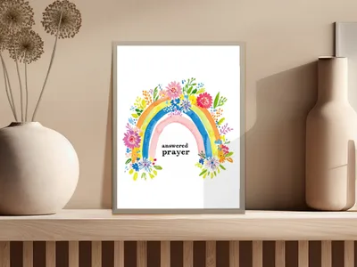 Rainbow with flowers and text "answered prayer" in a framed print.