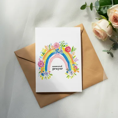 Card with rainbow and floral design, text "answered prayer" inside an envelope.