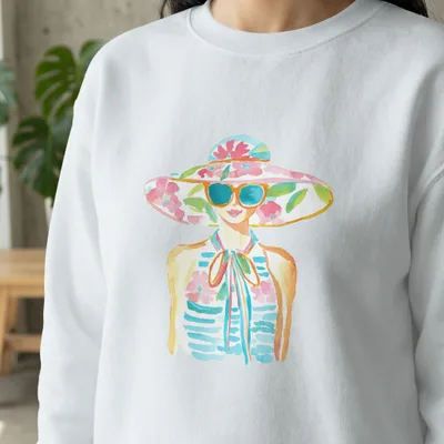 Woman wearing a white sweatshirt with a watercolor floral hat and sunglasses.