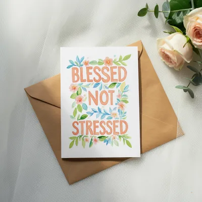 Greeting card with "Blessed Not Stressed" text and floral accents on envelope.