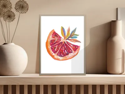 Watercolor painting of a sliced grapefruit with colorful leaves in a frame.
