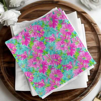 Pink and teal floral pattern on white napkins on a wooden tray.