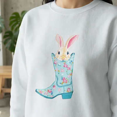White sweatshirt with blue floral boot and bunny graphic.