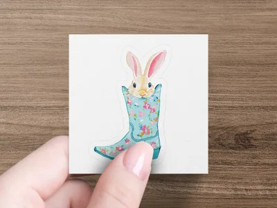 Cute bunny peeking from a floral patterned blue boot.