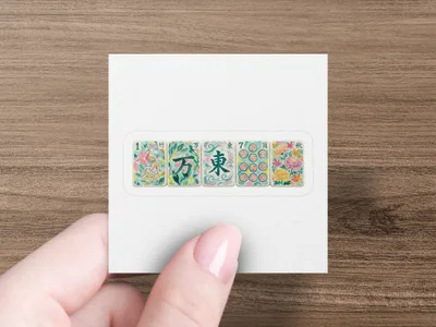 Hand holding a square sticker with five Mahjong tiles: one bamboo, three character tiles, and one autumn tile.