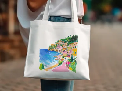 White tote bag with vibrant watercolor painting of a coastal village scene.
