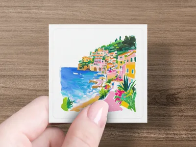 Watercolor painting of colorful coastal village with blue sea and green hills.