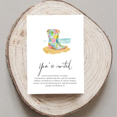 Invitation with floral cowboy boot on beach and placeholder text.