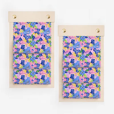 Two fabric swatches with a bright floral pattern of blue, pink, and purple flowers.