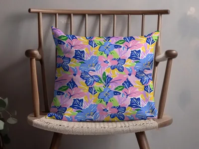 Colorful floral pattern throw pillow on a wooden chair.