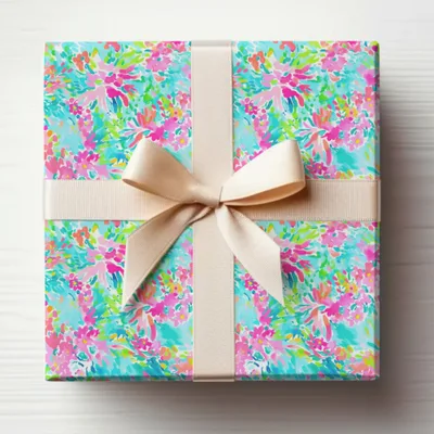 Gift-wrapped box with colorful floral pattern and beige ribbon.