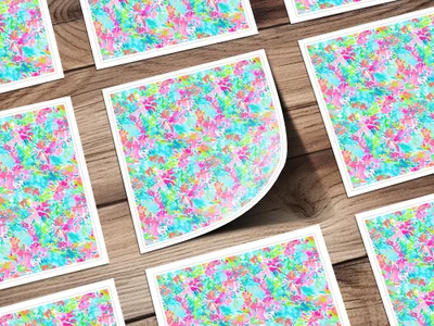 Floral pattern on white cards with rounded corners on a wooden surface.