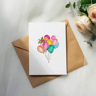 White card with colorful balloons and flowers on a brown envelope.