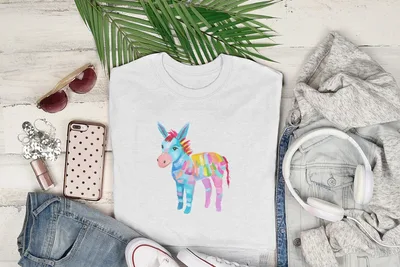 White t-shirt with colorful watercolor donkey graphic, on a flat lay with jeans and headphones.