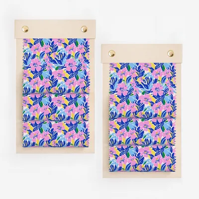 Two swatches of fabric with a vibrant blue, pink, and yellow floral pattern.