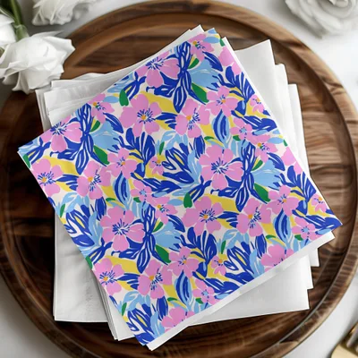White cloth napkins with a colorful floral pattern of pink, blue, and yellow flowers.