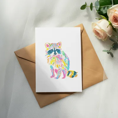 Watercolor raccoon illustration on a white card with a brown envelope.