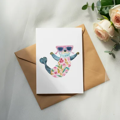 Watercolor illustration of a seal wearing sunglasses and a floral swimsuit on a card.