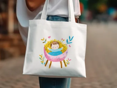 White tote bag with colorful baby Jesus in a manger illustration.