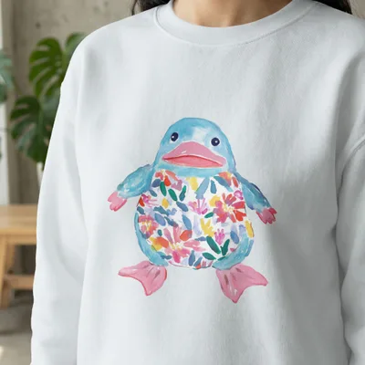 White sweatshirt featuring a cartoon blue bird with floral pattern.