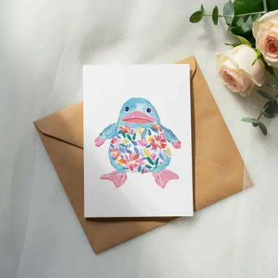 Watercolor blue duckling with floral pattern on white card on brown envelope.