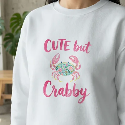 White sweatshirt with "CUTE but Crabby" text and a floral crab illustration.
