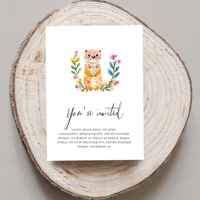 Invitation with watercolor otter and floral wreath, "You're invited" text.