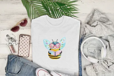 White t-shirt with cartoon bee wearing glasses and reading a book.