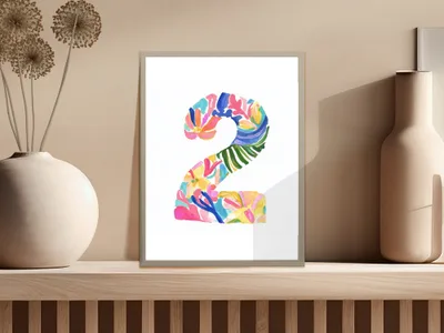 Colorful watercolor number 2 with floral and leaf patterns on a shelf.
