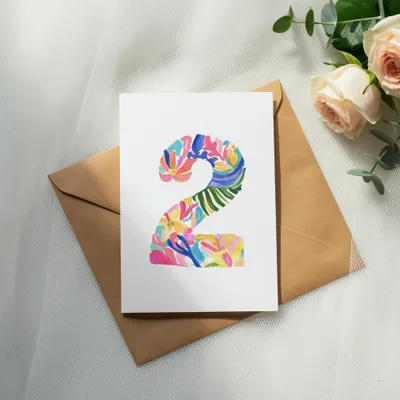 Card with a colorful floral number "2" on a brown envelope.