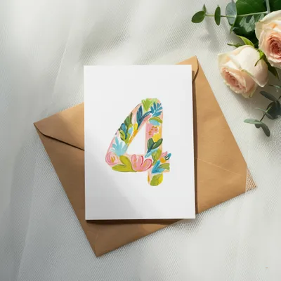 White card with floral number 4 design on brown envelope with roses.